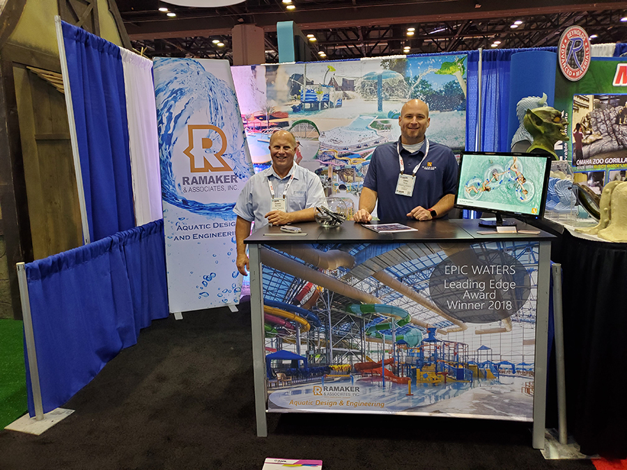 Daryl Matzke and Eric Kaul stand at Ramaker's booth at IAAPA Expo 2021